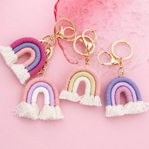 Detailed macro view of four handmade bohemian cotton woven rainbow keychains with gold clasps