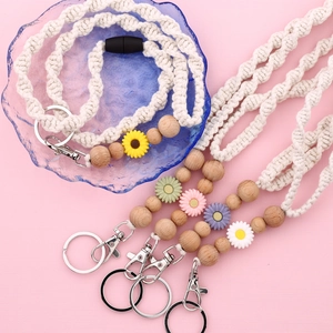Detailed macro view of woven daisy keychains with wooden beads and metal lobster clasps