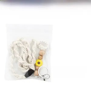 Detail of sunflower macramé lanyard with wooden beads and key ring in clear packaging