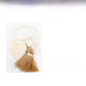 Detail view of dual-tone cotton tassel charms in cream and tan colors for handmade bags