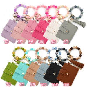 Array of colorful silicone bead bracelet keychains with leather card holder and tassel charms