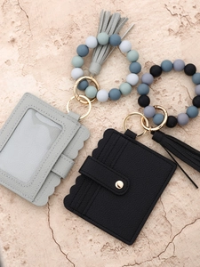 Detail view of leather card holder wallet with silicone bead wristlet and PU tassel