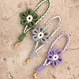 Handmade woven floral wrist straps in green, gray, and purple with golden lobster clasps