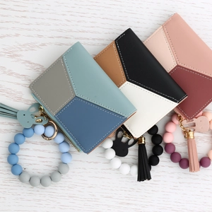 Overhead view of geometric PU leather mini wallets with silicone bead bracelets and tassels