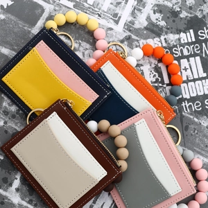 Detail of colorful silicone bead wristlet and leather wallet with gold keychain ring