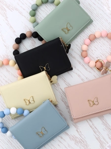 Close-up of colorful butterfly card wallets with silicone beaded wristbands and charms