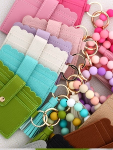 Detail of colorful silicone bead bracelet with PU leather wallet and tassel keychain set