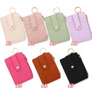 Dettaglio di portacarte intrecciati in sette colori con tasca a zip e anello portachiavi