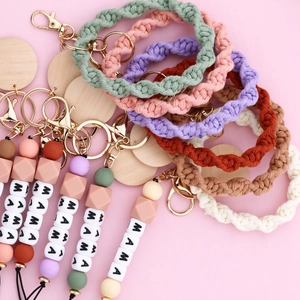 Detail of boho woven wristlet keychains with MAMA beads and golden lobster clasps