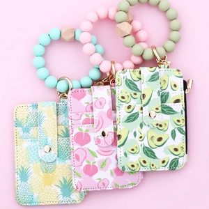 Detail of printed PU leather card holder with silicone bead wristlet and gold carabiner