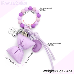 Purple silicone bead keychain with lavender fabric bow, heart tag, and leather tassel charm