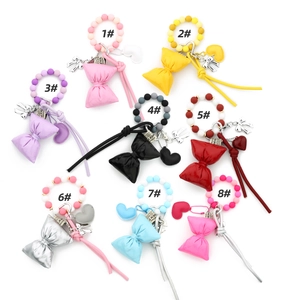 Flat lay of colorful silicone bead bracelets with heart and ribbon bow charms in 8 styles