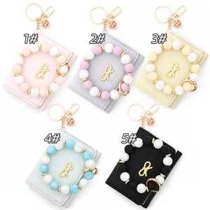 Five assorted colors of leather bowknot card holders with beaded wristlet keychains