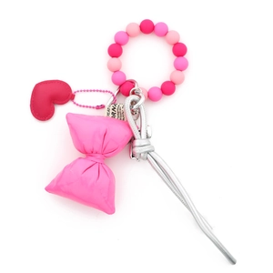 Detail of pink silicone bead keychain with large fabric candy and red leather heart