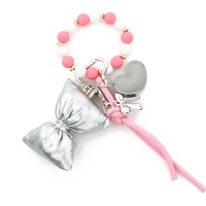 Macro detail of silicone bead wristlet with silver bow and heart leather charm