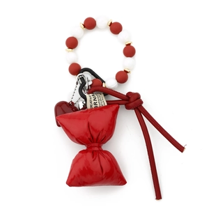 Detail of red silicone bead bracelet with a bow charm and heart accessory on a metal hook