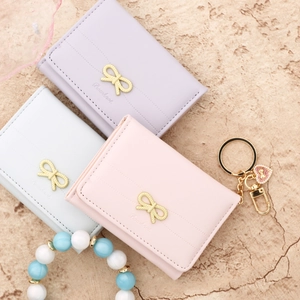 Three-fold leather women's wallet with golden bowknot accent in pink, purple and white