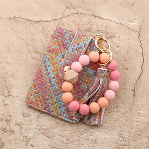 Flat lay of woven texture card wallet with gradient silicone bead tassel keychain