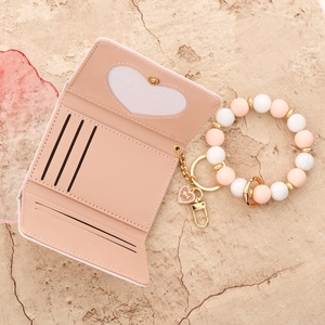 Pink trifold wallet with bow, heart window, credit card slots and beaded keychain strap