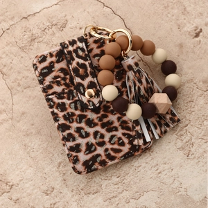 Close-up of leopard print card wallet with silicone beaded wristlet and tassel charm