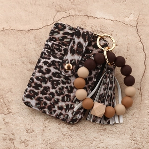 Detail of leopard print leather card holder with silicone beaded wristlet and gold hardware