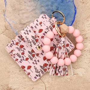 Detail of pink floral card holder with silicone bead bracelet and PU leather tassel keychain