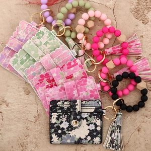 Detail of floral printed card wallet sets with silicone bead bracelets and tassels