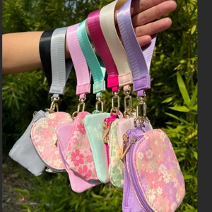 Detail von bunten wasserfesten Nylon-Handgelenktaschen mit Blumenmustern und Karabiner