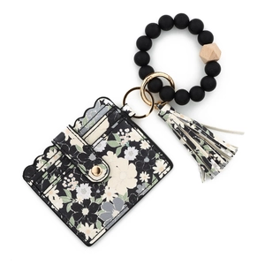 Macro view of black floral card holder keychain with silicone beads and gold metal ring