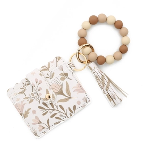 Detail of floral PU leather card holder with silicone bead bracelet and gold hardware