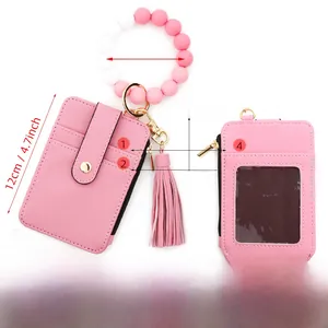 Geldbörse aus rosa Leder mit Litschi-Muster, Silikon-Armband und Quasten-Anhänger