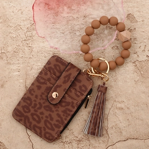 Detailansicht von Leopard-Kartenetui und Silikon-Perlenarmband mit Schlüsselanhänger