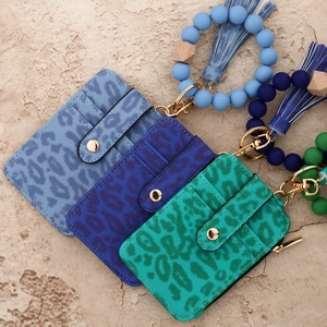 Kartenhalter mit Leopardenmuster in Blau und Türkis mit Perlenarmband und Goldbeschlägen