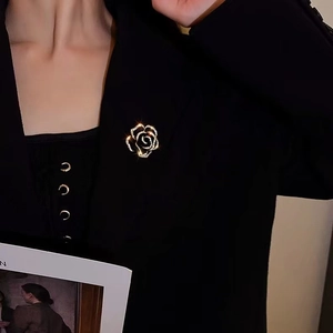Elegant silver rose brooch with white zircons pinned on a black suit jacket lapel