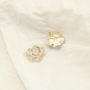 Detailed macro view showing the front and back of a rose brooch with rhinestones
