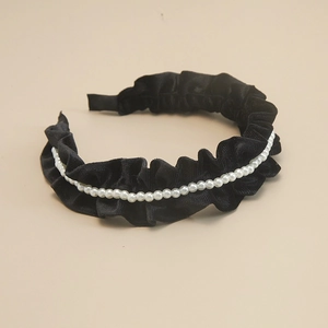 Detail of elegant black velvet pleated headband decorated with glossy white pearls