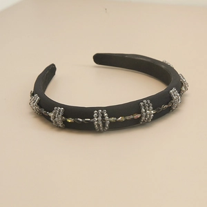 Detailed view of black fabric headband with grey crystal bead embellishments in baroque style