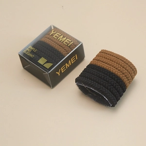 Close-up of elastic woven hair ties in black and brown within a transparent gift box