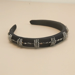 Close-up of elegant black satin headband with gray crystal beads and vintage baroque style