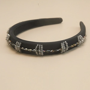 Detailed view of handmade baroque headband with grey crystal beads on black satin fabric
