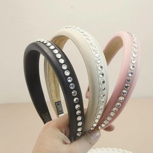 Close-up of handmade leather headbands with rhinestones in black pink and beige