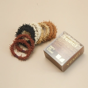 Vue détaillée des élastiques à cheveux en peluche tons terre avec une boîte cadeau élégante