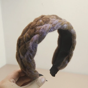 Detail of handmade braided headband with brown and purple thick wool yarn texture
