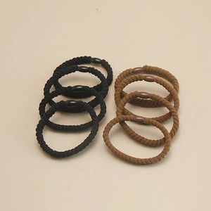 Close-up of black and coffee braided hair ties with round beads in a detail macro shot