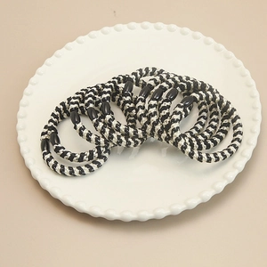Detail of hand-woven black and white elastic hair ties with black oval bead accents