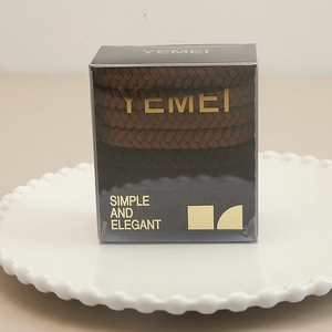Detail of boxed high elasticity brown woven hair scrunchies on elegant ceramic plate
