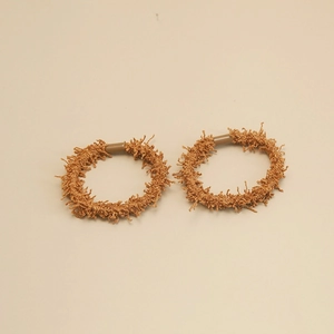 Détail de deux chouchous en chenille marron avec texture douce et haute élasticité