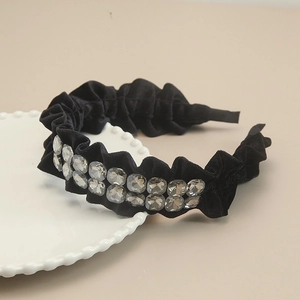 Detailed close-up of a black velvet headband with elegant double-row crystal rhinestones