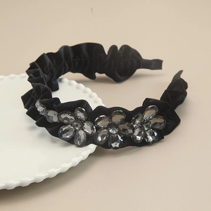 Close-up of black velvet headband with elegant gray crystal flower embellishments
