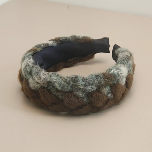 Detail of bohemian braided headband featuring mixed dark brown, grey, and light blue yarn